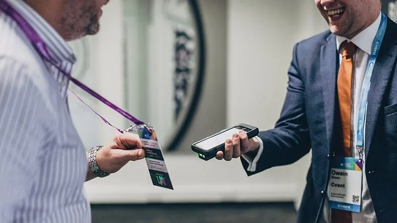 Event staff member scanning an attendee’s badge with a handheld scanner