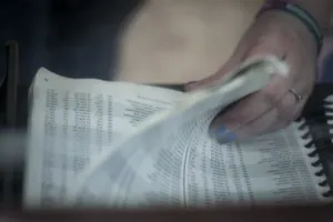 Hands flipping through the pages of a phone book