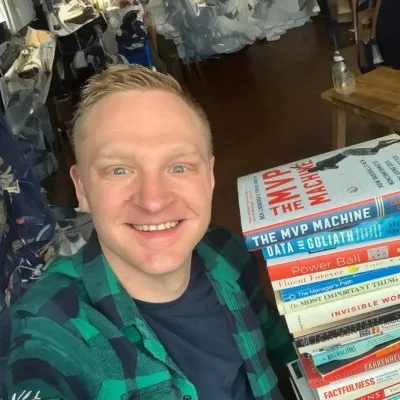 Portrait of Brian Haveri, VP of Engineering at TrainingPeaks, next to a stack of business books