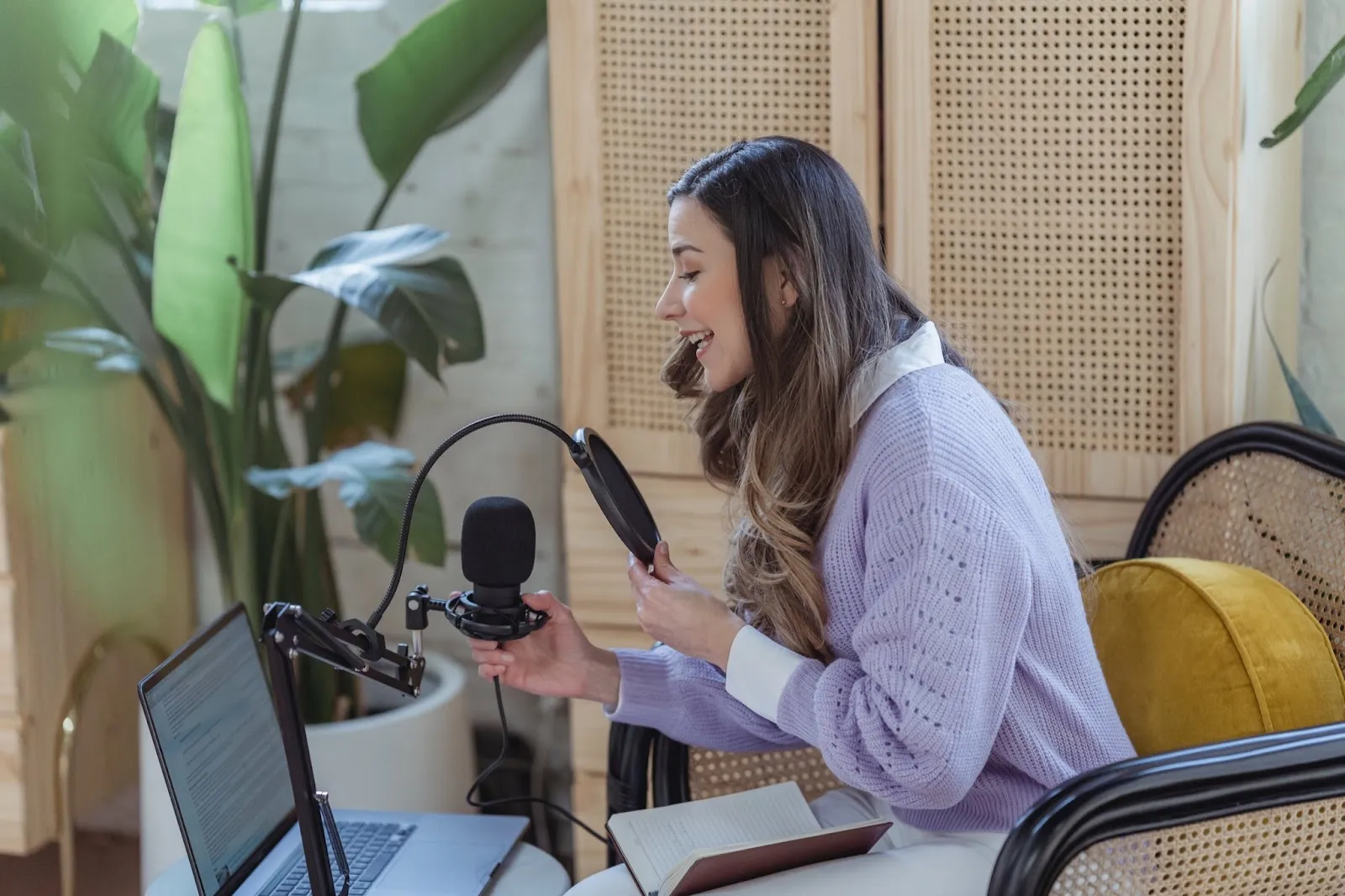 Woman recording a podcast with a microphone and laptop