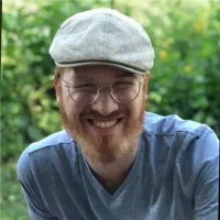 Portrait of Sam Reis, VP Engineering at lemon.markets, in a flat cap outdoors